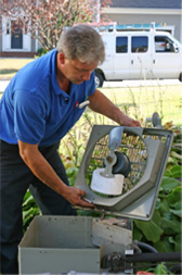 One of our certified air conditioning service men repairing an outdoor ac unit